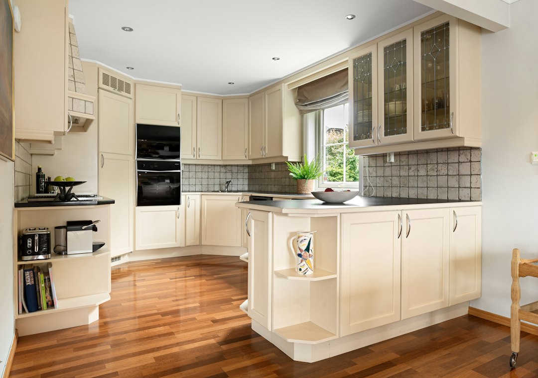 A finished fitted kitchen in a house, daylight from the window over the worktop