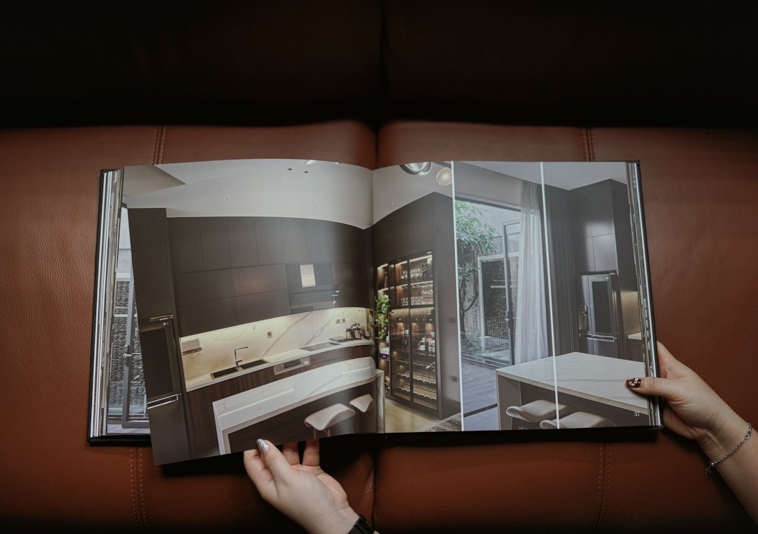 An open printed catalogue, a full page photograph of a fitted kitchen across the spread