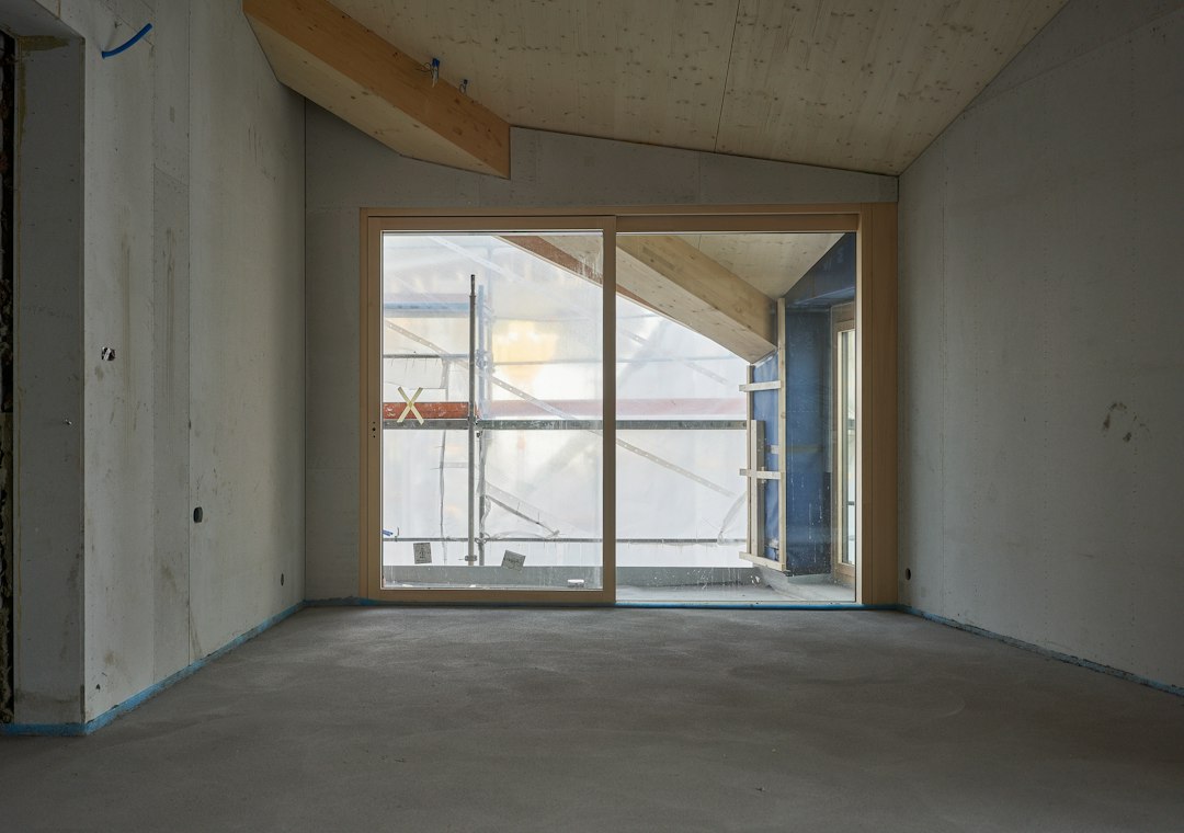 A large glazed unit fitted into a concrete opening on a building site