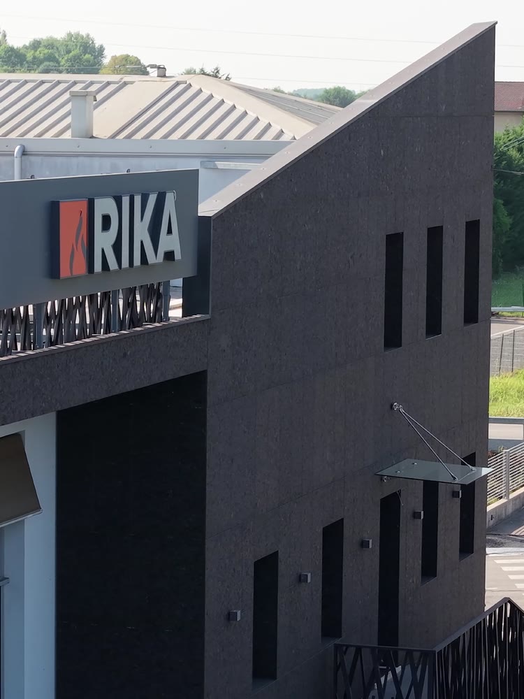 El edificio de la tienda Rika, con revestimiento oscuro y el rótulo Rika iluminado