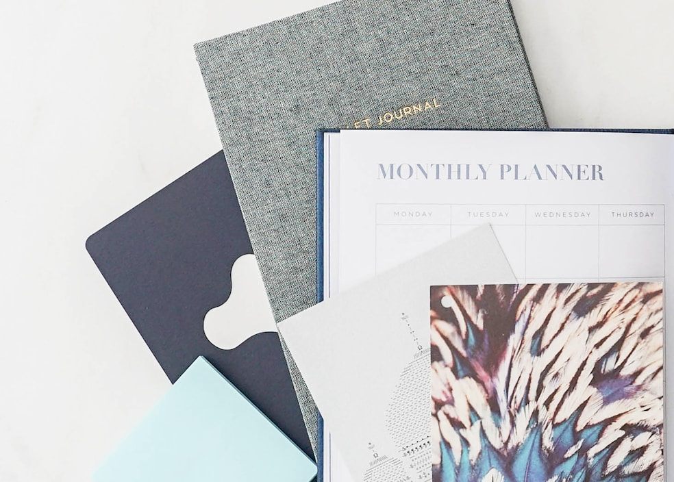A planner and journals arranged on a desk