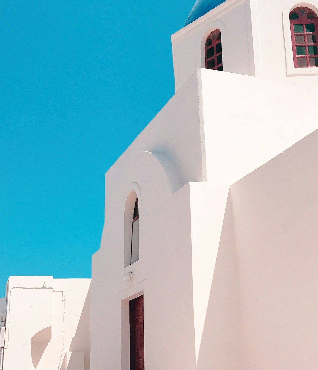 White Cycladic architecture against a vivid blue sky