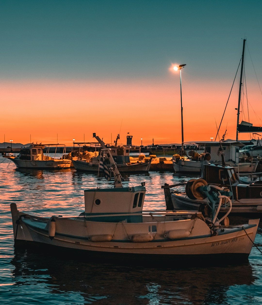 Fishing boats in a harbour at sunset
